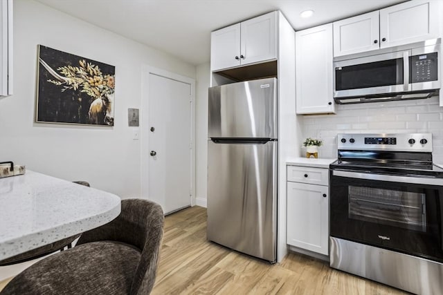 34 Bayview Ter Unit 3, Danvers, MA 01923 - kitchen with appliances with stainless steel finishes, white cabinets, light wood-style flooring, backsplash, and recessed lighting