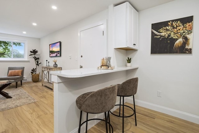 34 Bayview Ter Unit 3, Danvers, MA 01923 - kitchen featuring a breakfast bar, white cabinetry, light wood-style floors, recessed lighting, and baseboards