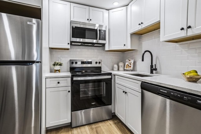 34 Bayview Ter Unit 3, Danvers, MA 01923 - kitchen featuring stainless steel appliances, a sink, white cabinets, decorative backsplash, and light stone counters