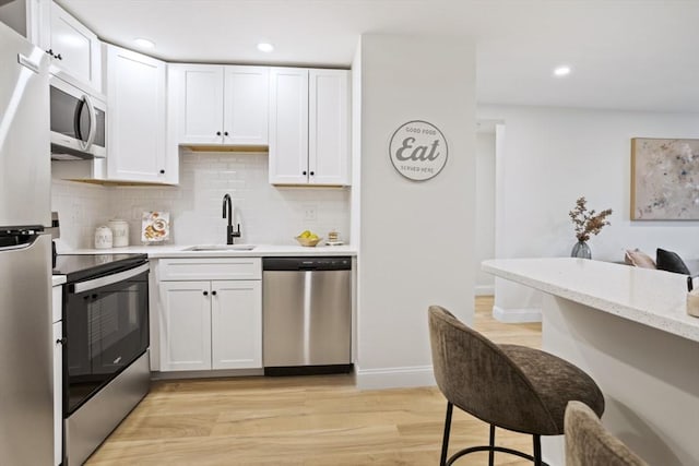 34 Bayview Ter Unit 3, Danvers, MA 01923 - kitchen featuring stainless steel appliances, backsplash, a sink, white cabinets, and recessed lighting