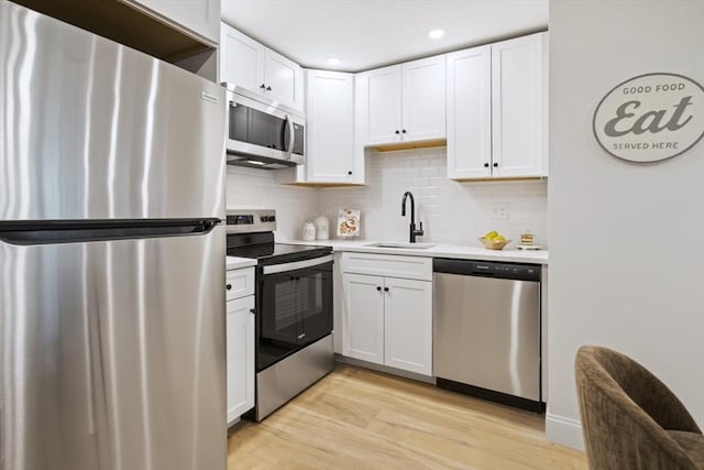 34 Bayview Ter Unit 3, Danvers, MA 01923 - kitchen with stainless steel appliances, a sink, light wood finished floors, light countertops, and white cabinetry