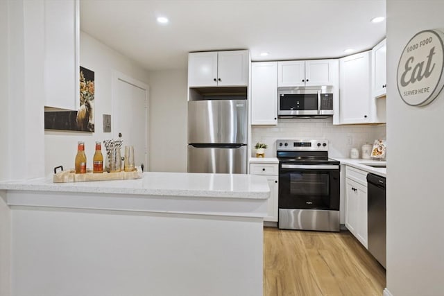 34 Bayview Ter Unit 3, Danvers, MA 01923 - kitchen with appliances with stainless steel finishes, a peninsula, white cabinetry, light wood-style floors, and recessed lighting