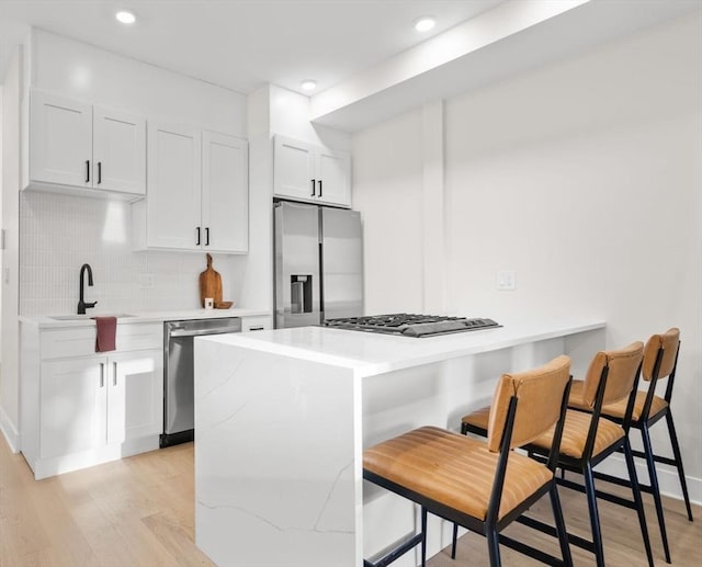 62 Haynes Unit 201, Boston, MA 02128 - kitchen with stainless steel appliances, a sink, a kitchen bar, light wood-style flooring, and recessed lighting