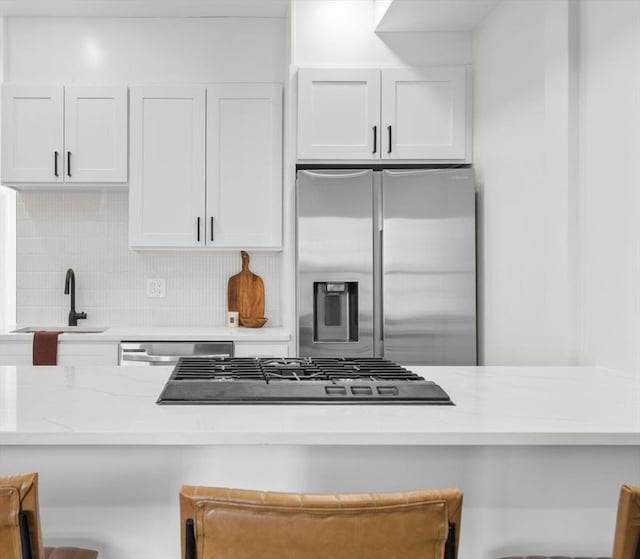 62 Haynes Unit 201, Boston, MA 02128 - kitchen with stainless steel appliances, a sink, decorative backsplash, and white cabinetry