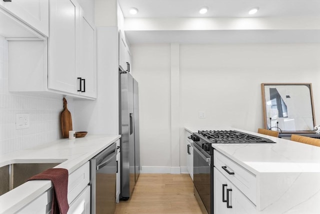 62 Haynes Unit 201, Boston, MA 02128 - kitchen with stainless steel appliances, light wood-style flooring, light stone countertops, decorative backsplash, and white cabinets