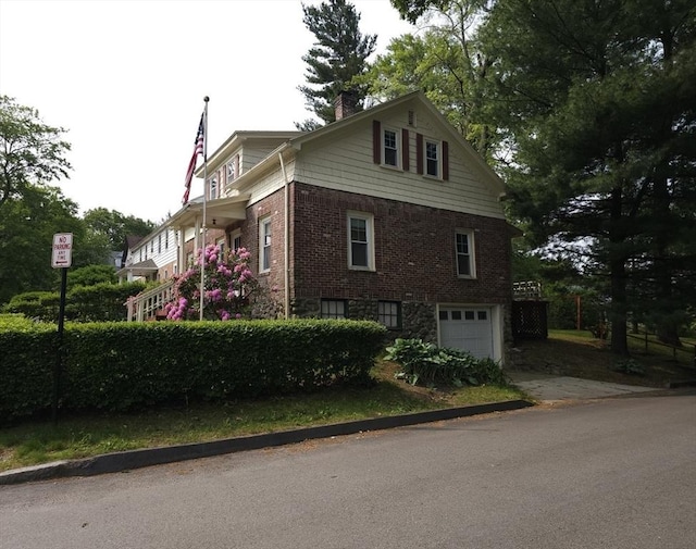 45 Circuit Ave E, Worcester, MA 01603 - view of home's exterior featuring an attached garage, a chimney, brick siding, and driveway