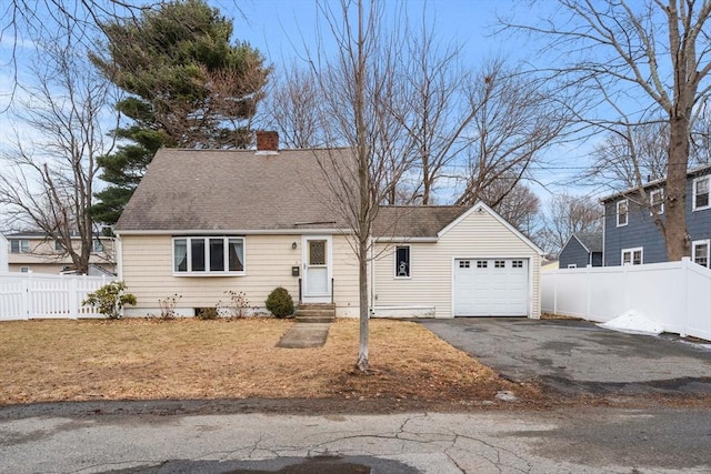 new england style home with fence, entry steps, a chimney, a garage, and driveway