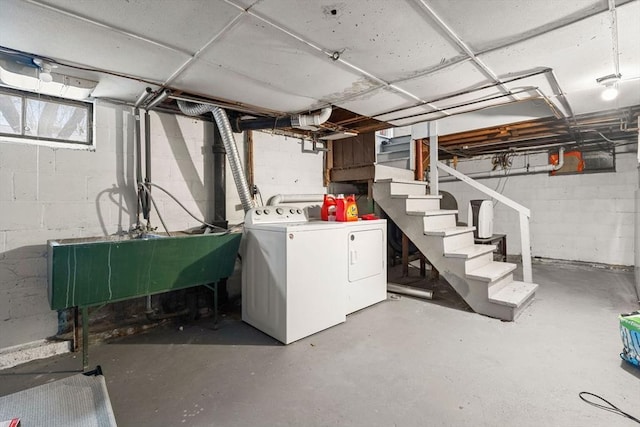 unfinished below grade area featuring stairway, separate washer and dryer, and a sink