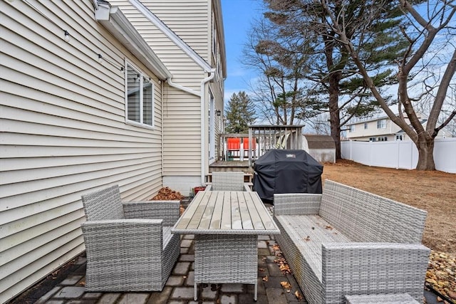 deck with an outdoor living space, fence, and a grill