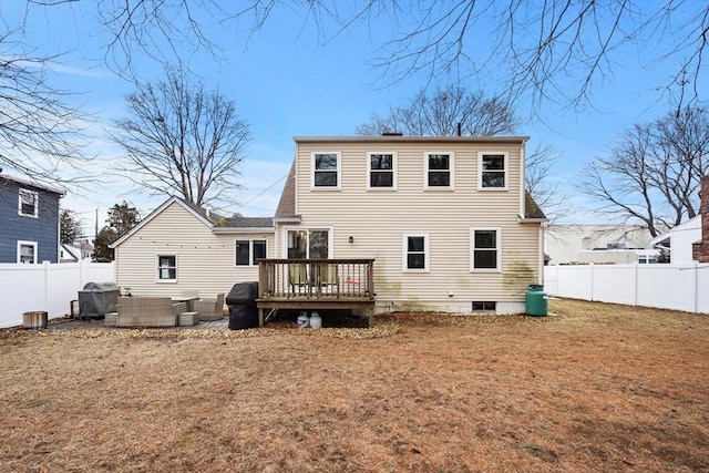 back of property featuring a lawn, a wooden deck, and a fenced backyard