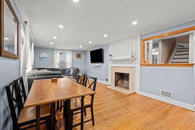 dining area featuring visible vents, baseboards, recessed lighting, a fireplace, and wood finished floors