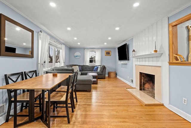 dining room featuring recessed lighting, baseboards, light wood-style floors, and a fireplace