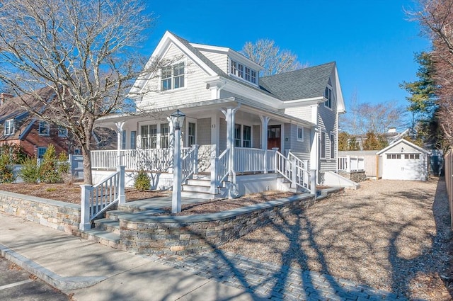 view of front of home featuring an outbuilding, a detached garage, a shingled roof, covered porch, and driveway