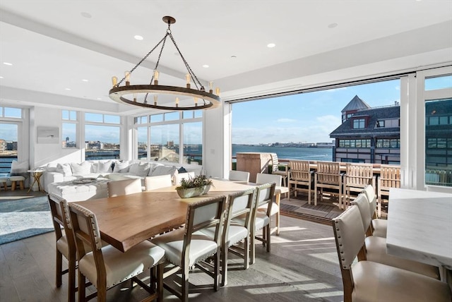 dining room featuring hardwood / wood-style floors, a water view, plenty of natural light, and a notable chandelier