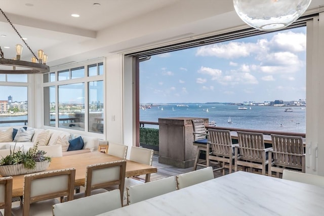 bedroom featuring a water view and a notable chandelier