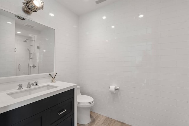 bathroom featuring walk in shower, toilet, vanity, and hardwood / wood-style flooring