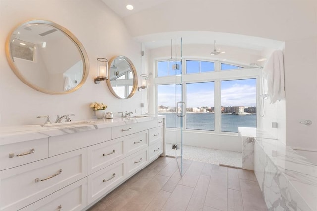 bathroom featuring vanity, a water view, an enclosed shower, and vaulted ceiling