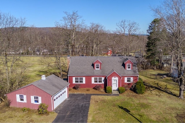 cape cod home with driveway, a front yard, an outdoor structure, and roof with shingles