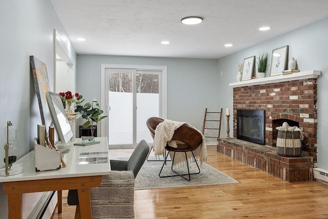 interior space with recessed lighting, a fireplace, and light wood finished floors