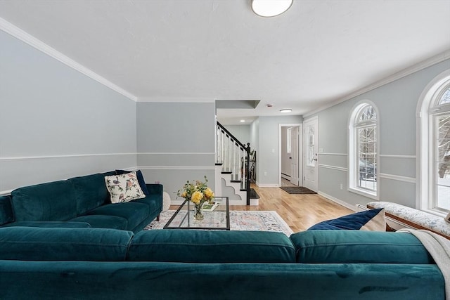 living area featuring ornamental molding, stairs, baseboards, and wood finished floors