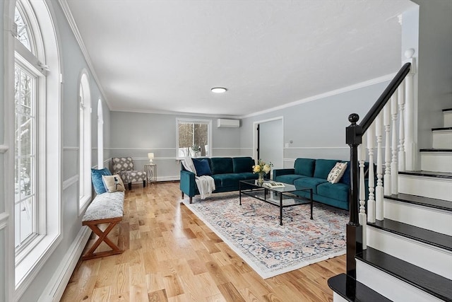 living area featuring crown molding, light wood-type flooring, and a wall mounted air conditioner