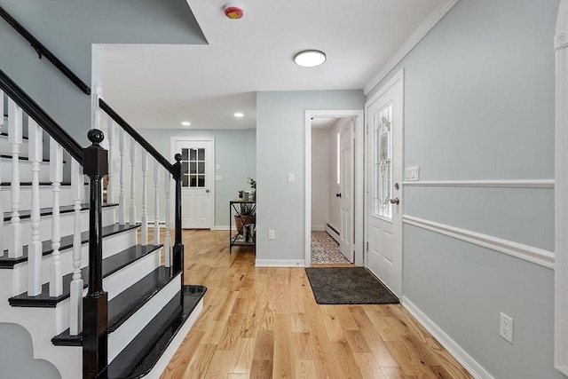 foyer entrance featuring a baseboard heating unit, recessed lighting, stairway, light wood-style floors, and baseboards