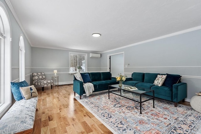 living area featuring baseboards, light wood-style flooring, crown molding, and a wall unit AC