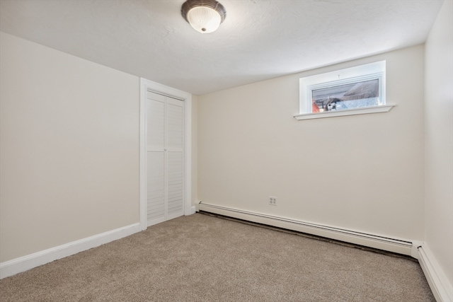 spare room with a baseboard heating unit, carpet floors, and a textured ceiling