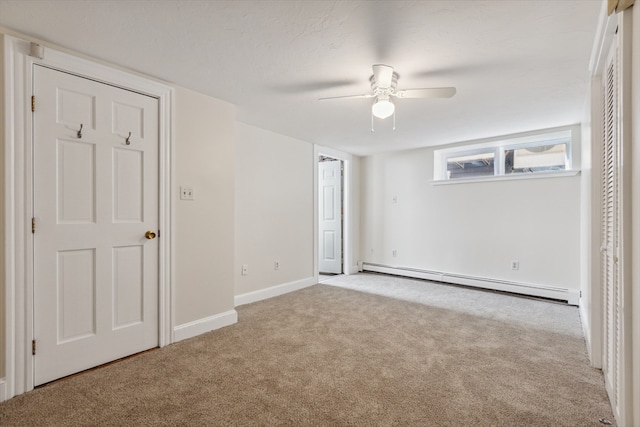 unfurnished bedroom featuring a baseboard heating unit, light carpet, and ceiling fan