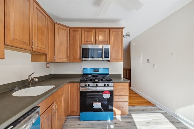 kitchen with sink, light wood-type flooring, and appliances with stainless steel finishes