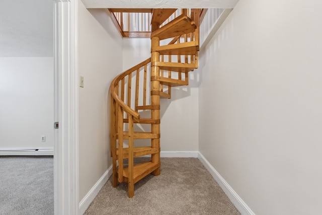 stairway featuring a baseboard heating unit and carpet floors