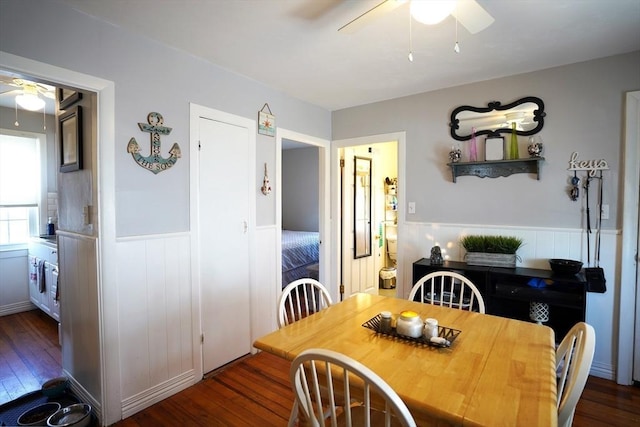 dining room featuring a ceiling fan, wainscoting, and dark wood-style floors