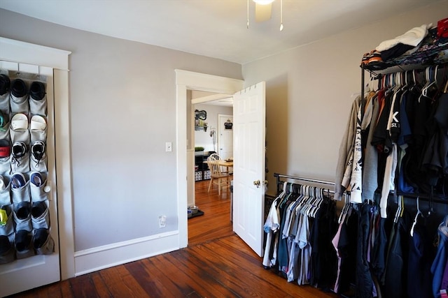 spacious closet with dark wood finished floors and a ceiling fan