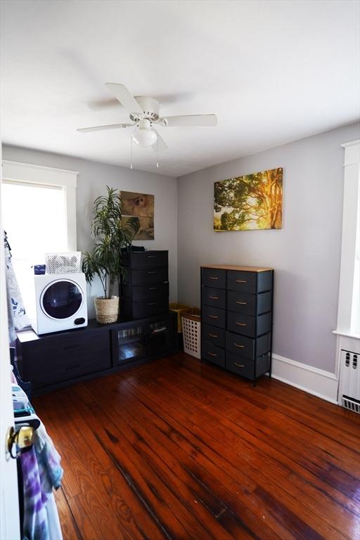 interior space featuring ceiling fan, hardwood / wood-style floors, radiator heating unit, and baseboards