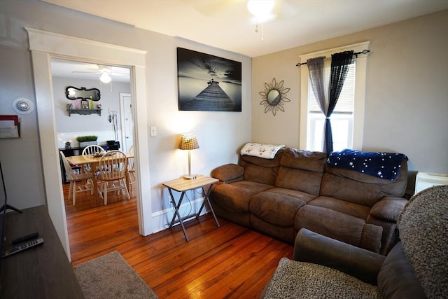 living room featuring ceiling fan, wood finished floors, and baseboards