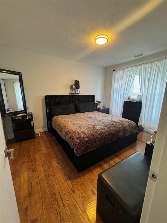 bedroom featuring hardwood / wood-style flooring and a textured ceiling