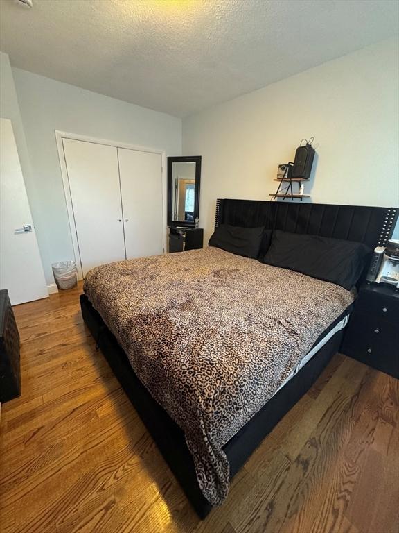 bedroom featuring a textured ceiling, a closet, and light wood-type flooring