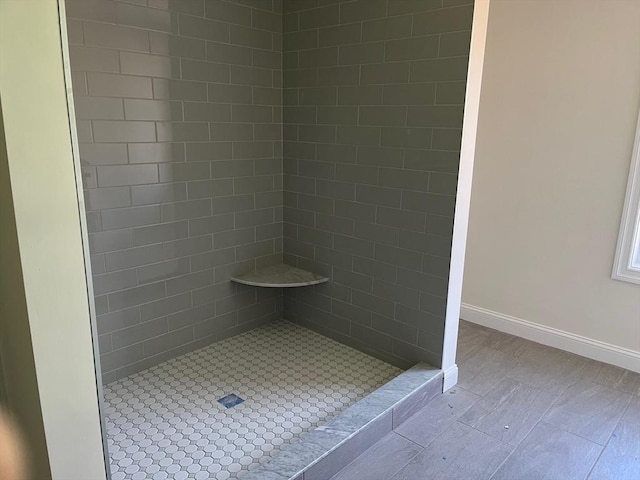 full bathroom featuring a stall shower and baseboards