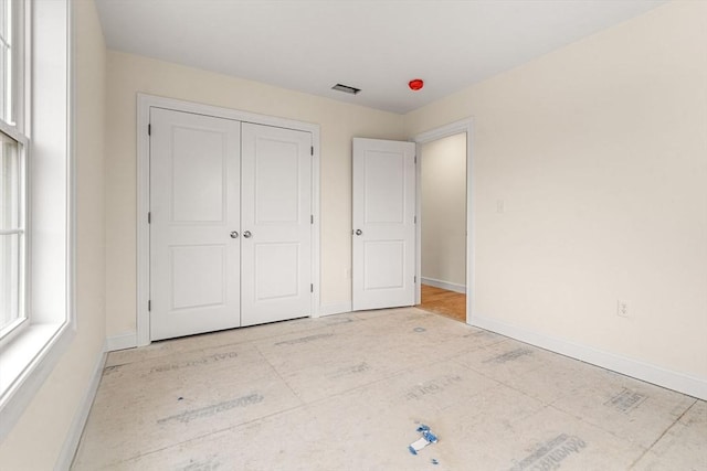 unfurnished bedroom featuring a closet, visible vents, and baseboards