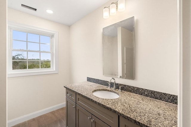 bathroom with baseboards, visible vents, wood finished floors, and vanity