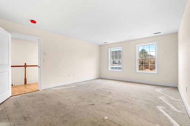 unfurnished room with baseboards