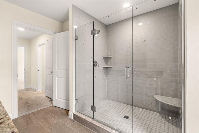 bathroom with a shower stall and baseboards