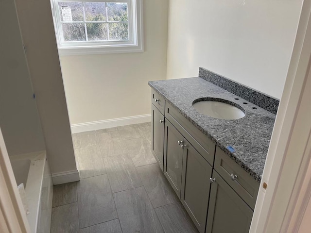 full bathroom with vanity and baseboards