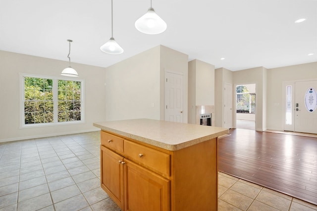 kitchen featuring heating unit, light hardwood / wood-style flooring, hanging light fixtures, and a center island