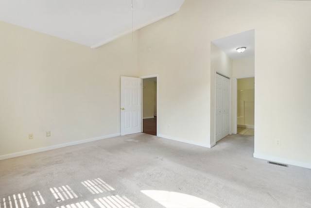 carpeted spare room with a high ceiling