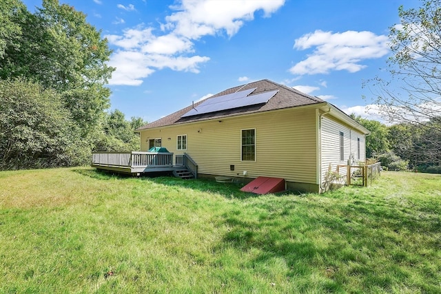 rear view of house featuring a deck and a yard