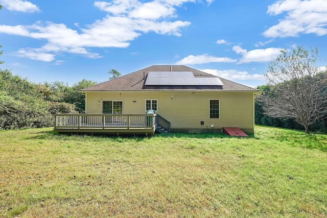 back of house featuring solar panels, a deck, and a yard