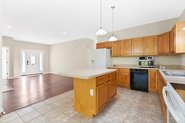 kitchen with pendant lighting, a center island, sink, light hardwood / wood-style flooring, and white appliances