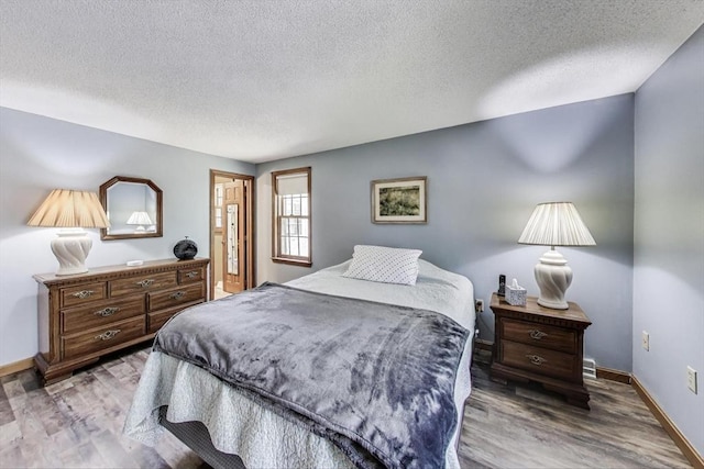 49 Lady Slipper Dr, Dennis, MA 02638 - bedroom featuring baseboards, a textured ceiling, and wood finished floors