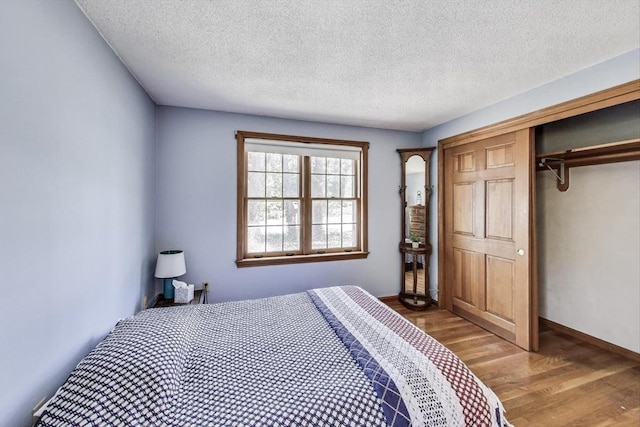 49 Lady Slipper Dr, Dennis, MA 02638 - bedroom featuring a closet, a textured ceiling, and wood finished floors